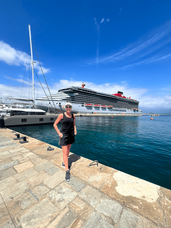 Jenny Lynn Anderson standing in front of the Virgin Voyages Scarlet Lady Cruise.