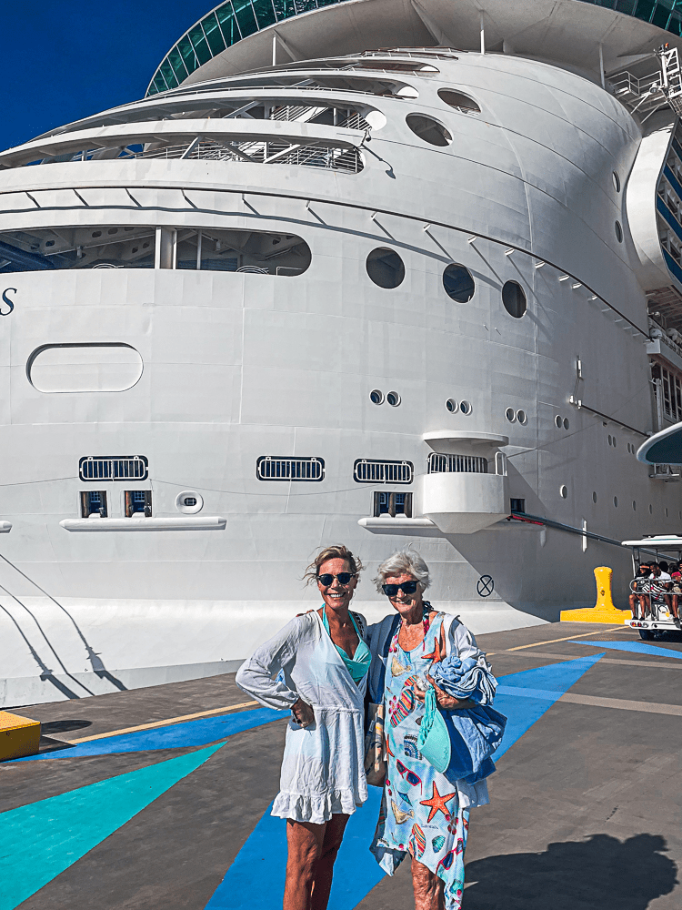 Jenny Lynn and a friend wearing comfortable clothes in front of a cruise.