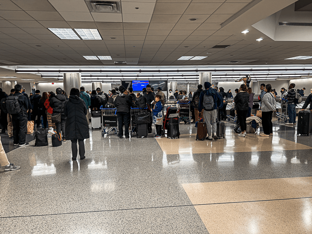 People waiting for their luggage at a carousel at the airport.