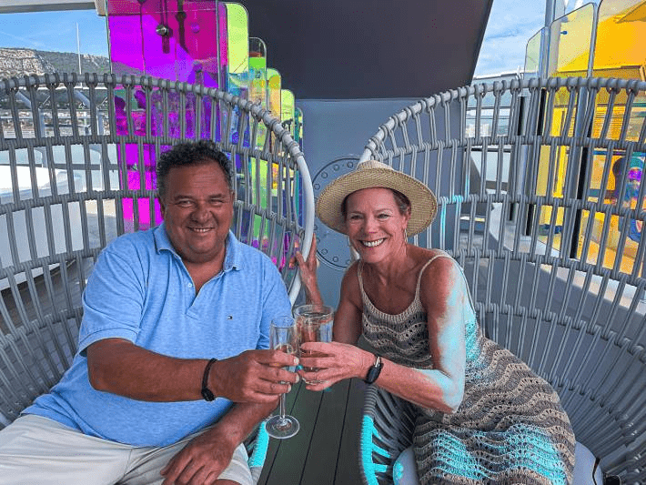 A man and a woman cheering during a cruise.