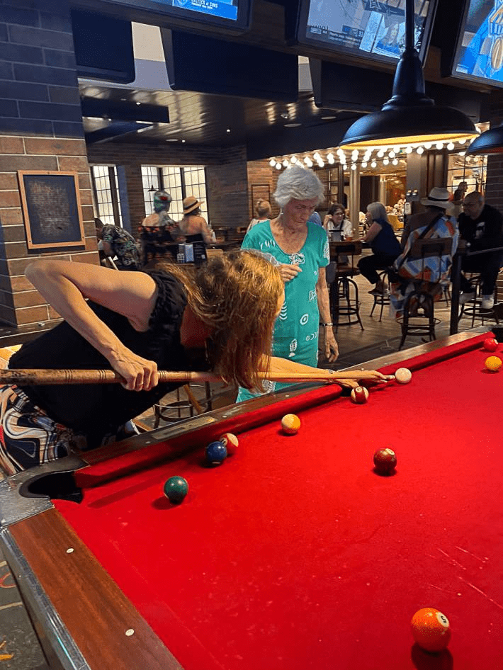 Two women playing pool on a cruise.