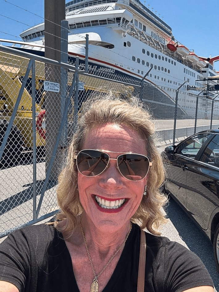 Selfie of Jenny Lynn Anderson in front of a cruise.