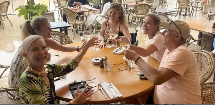 Jenny Lynn on a Journey travel group toasting a glass of wine and laughing.