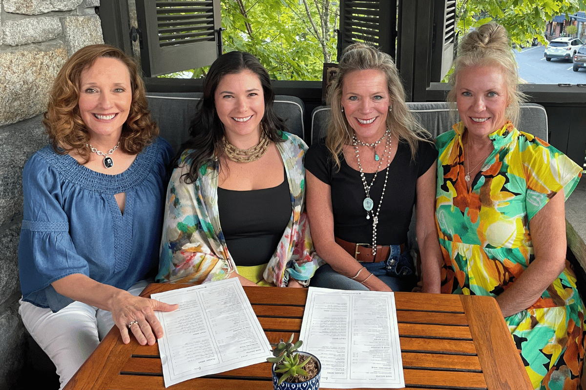 four women sitting at a table during a savannah girls trip.